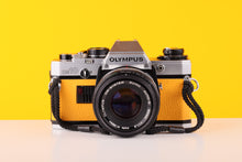 Load image into Gallery viewer, Olympus OM10 35mm SLR Film Camera with Olympus F.Zuiko Auto-S 50mm f1.8 Lens in Yellow