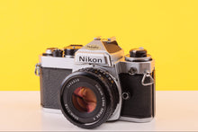 Load image into Gallery viewer, Vintage Nikon camera on a yellow and white background