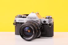 Load image into Gallery viewer, Canon AE-1 camera on a yellow background