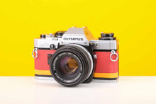 Load image into Gallery viewer, Olympus OM10 Slr Vintage 35mm Film Camera with Zuiko 50mm f1.8 Prime Lens with New Leather Red and Yellow Skin