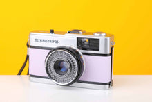 Load image into Gallery viewer, Olympus Trip 35 vintage 35mm film camera with a Zuiko 40mm f2.8 lens, displayed against a yellow background with a new lilac leather skin.