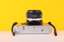 Load image into Gallery viewer, Olympus OM10 35mm SLR Film Camera with Olympus F.Zuiko Auto-S 50mm f1.8 Lens in Yellow with Manual Adapter