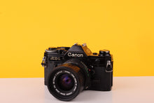 Load image into Gallery viewer, Canon AE-1 Black 35mm SLR Film Camera with Canon FD 35-70mm f/3.5-4.5 Zoom Lens