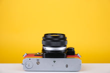 Load image into Gallery viewer, Olympus OM10 35mm SLR Film Camera with Zuiko 28mm f2.8 Prime Lens and Manual Adapter With New Leather Red and Yellow Skin