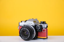 Load image into Gallery viewer, Olympus OM10 35mm SLR Film Camera with Zuiko 28mm f2.8 Prime Lens and Manual Adapter With New Leather Red and Yellow Skin
