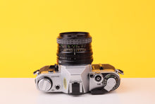Load image into Gallery viewer, Canon AE-1 35mm Film SLR Camera with Sigma Mini-Wide II 28mm f/2.8 Lens
