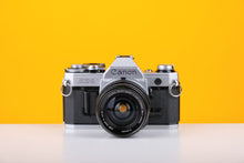 Load image into Gallery viewer, Canon AE-1 Silver 35mm SLR Film Camera with Sigma Mini-Wide 28mm f2.8 Lens
