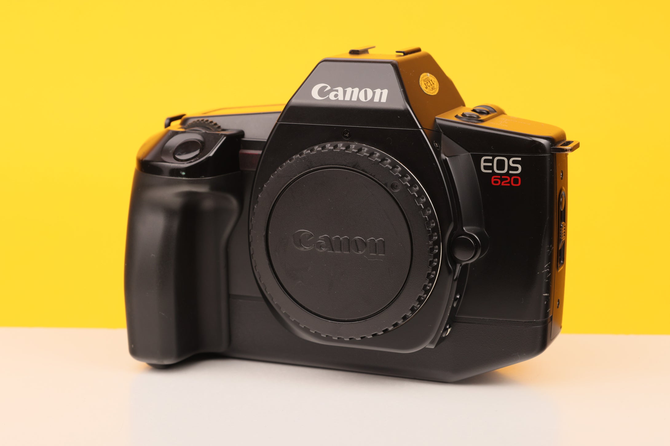 Canon EOS camera on a yellow and white background