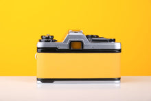Load image into Gallery viewer, Olympus OM10 35mm SLR Film Camera in Yellow with Tokina 28-70mm f/3.5-4.5 Zoom Lens
