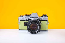 Load image into Gallery viewer, Olympus OM10 Slr Vintage 35mm Film Camera with Zuiko 50mm f1.8 Prime Lens Reconditioned With New Lime Leather Skin
