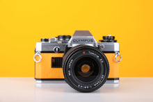 Load image into Gallery viewer, Olympus OM10 35mm SLR Film Camera in Yellow with Tokina 28-70mm f/3.5-4.5 Zoom Lens
