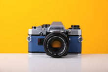 Load image into Gallery viewer, Olympus OM10 SLR Vintage 35mm Film Camera with Zuiko 50mm f/1.8 Prime Lens Reconditioned With New Blue Leather Skin
