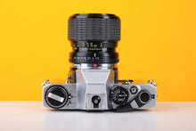 Load image into Gallery viewer, Olympus OM10 35mm SLR Film Camera in Yellow with Sigma 35-70mm f/2.8 Zoom Lens
