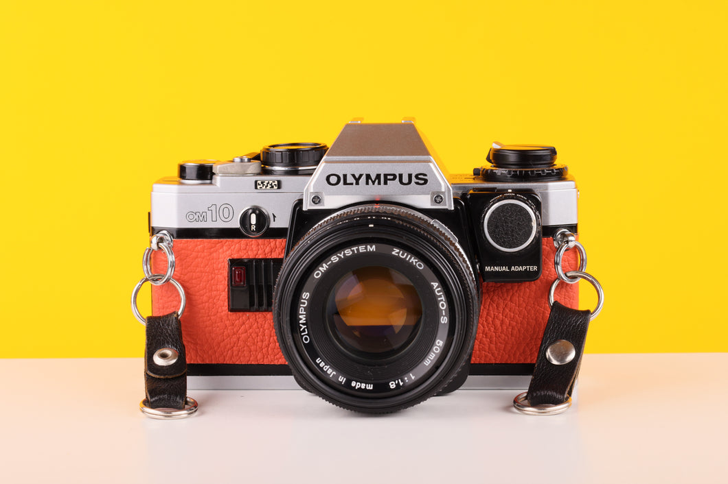 Olympus OM10 35mm SLR Film Camera with Manual Adapter and Olympus Zuiko Auto-S 50mm f1.8 Lens in Orange