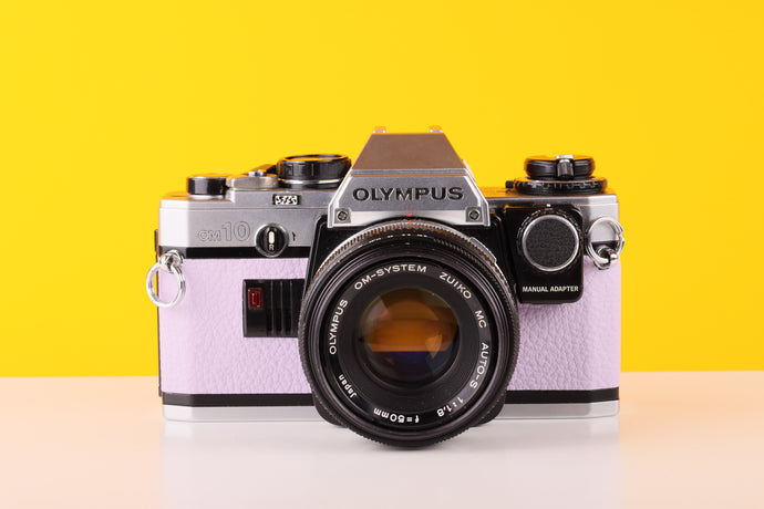 
Olympus OM10 35mm SLR Film Camera with Manual Adapter and Olympus Zuiko MC Auto-S 50mm f1.8 Lens in Lilac