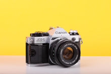 Load image into Gallery viewer, Canon AE-1 Program 35mm SLR Film Camera with Canon FD 50mm f/1.8 Lens – Boxed
