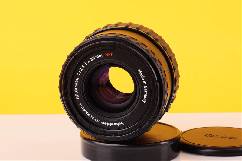 Camera lens with brand name on a yellow and beige background