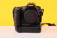 Load image into Gallery viewer, Canon camera body with battery grip on a yellow and white background
