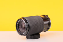 Load image into Gallery viewer, Camera lens on a yellow and beige background
