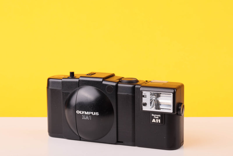 Vintage Olympus camera on a yellow background