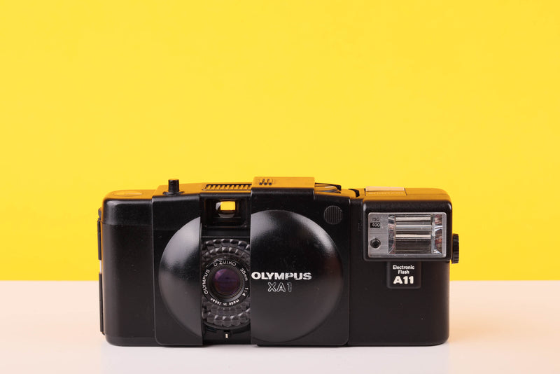 Vintage Olympus XA1 camera on a yellow background