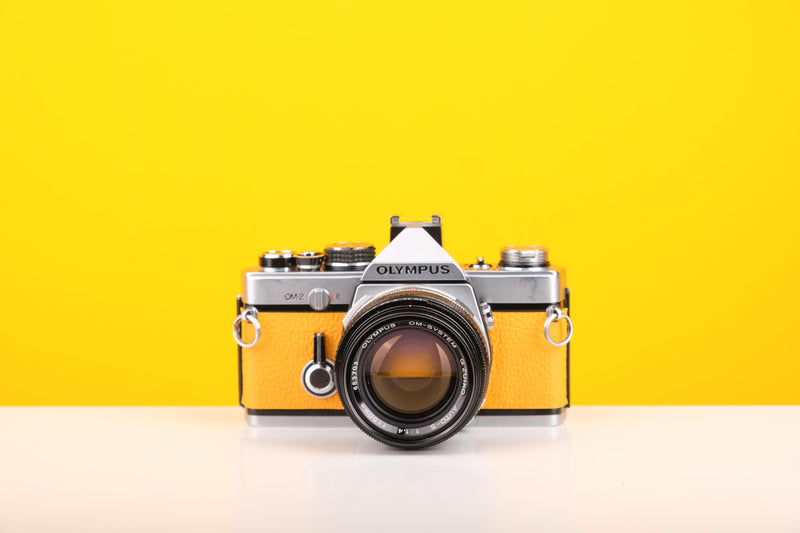 Olympus OM-2 35mm SLR Film Camera with Zuiko Olymplus OM-System G.Zuiko Auto-S 50mm f1.4 Lens in Yellow