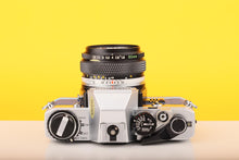 Load image into Gallery viewer, Olympus OM10 SLR Vintage 35mm Film Camera with Zuiko 50mm f/1.8 Prime Lens Reconditioned With New Blue Leather Skin
