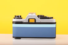 Load image into Gallery viewer, Olympus OM10 SLR Vintage 35mm Film Camera with Zuiko 50mm f/1.8 Prime Lens Reconditioned With New Blue Leather Skin
