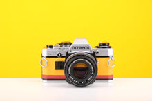 Load image into Gallery viewer, Olympus OM10 Slr Vintage 35mm Film Camera with Zuiko 50mm f1.8 Prime Lens and with New Leather Yellow and Red Skin
