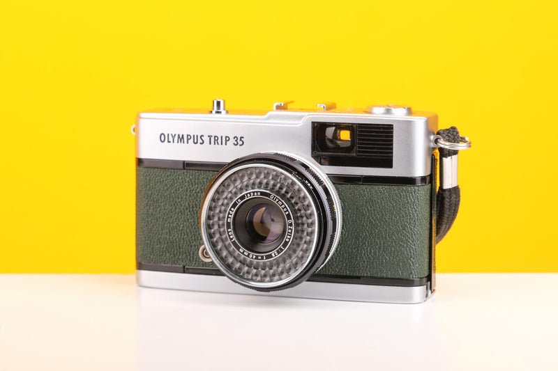 Vintage Olympus camera on a yellow background