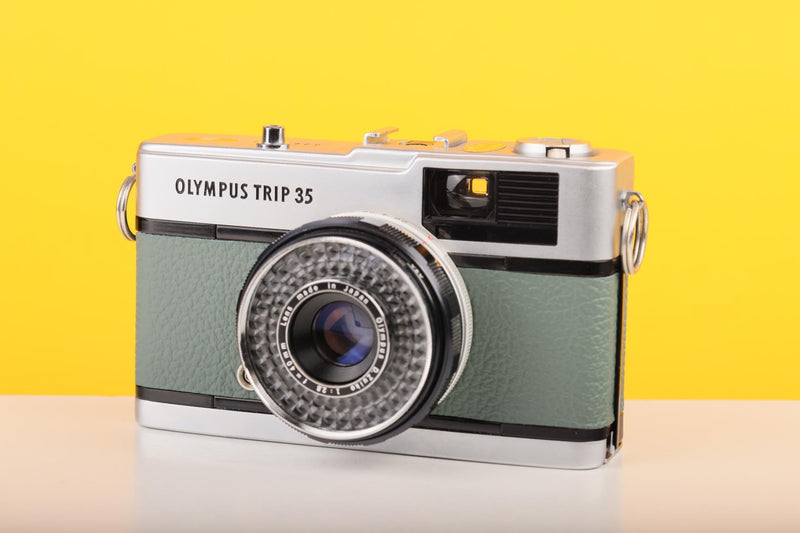 Vintage Olympus Trip 35 camera on a yellow background
