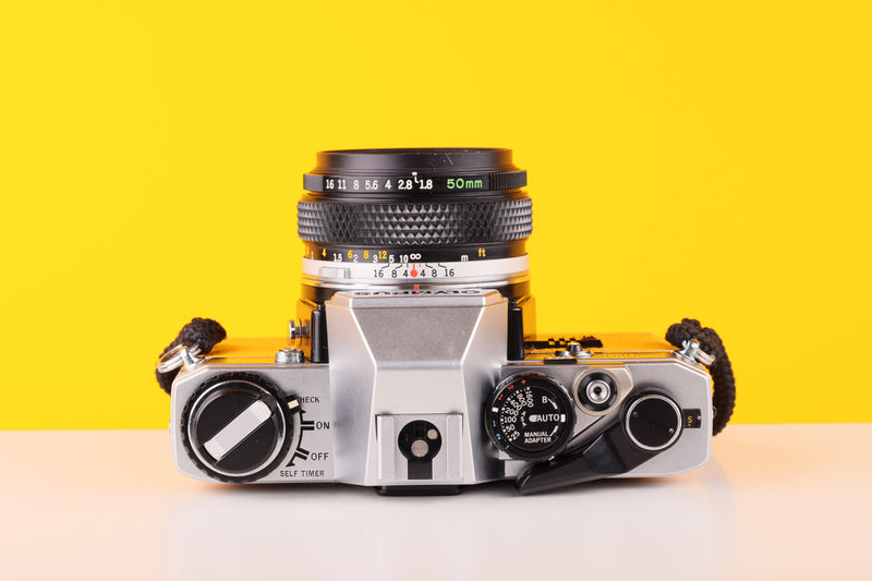 Olympus OM10 35mm SLR Film Camera with Olympus F.Zuiko Auto-S 50mm f1.8 Lens in Yellow with Manual Adapter