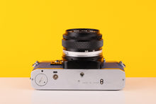 Load image into Gallery viewer, Olympus OM10 SLR Vintage 35mm Film Camera with Zuiko 50mm f/1.8 Prime Lens Reconditioned With New Blue Leather Skin
