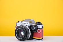 Load image into Gallery viewer, Olympus OM10 Slr Vintage 35mm Film Camera with Zuiko 50mm f1.8 Prime Lens  and Manual Adapter With New Leather Red and Yellow Skin
