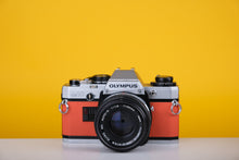Load image into Gallery viewer, Olympus OM10 Vintage Film Camera with 50mm f/1.8 Lens With New Orange Leather Skin
